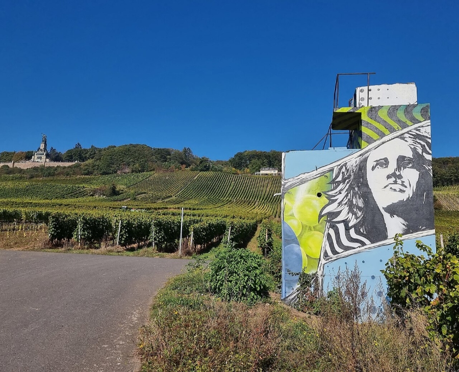Mural of a woman painted on a building amidst a vineyard in Rüdesheimer Berg Roseneck.