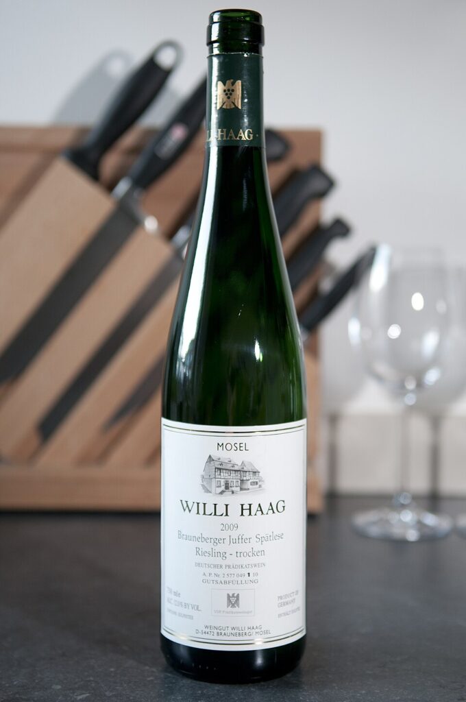 Willi Haag Braunberger Juffer Spätlese Riesling trocken bottle positioned on a counter with a knife nearby, highlighting its label.